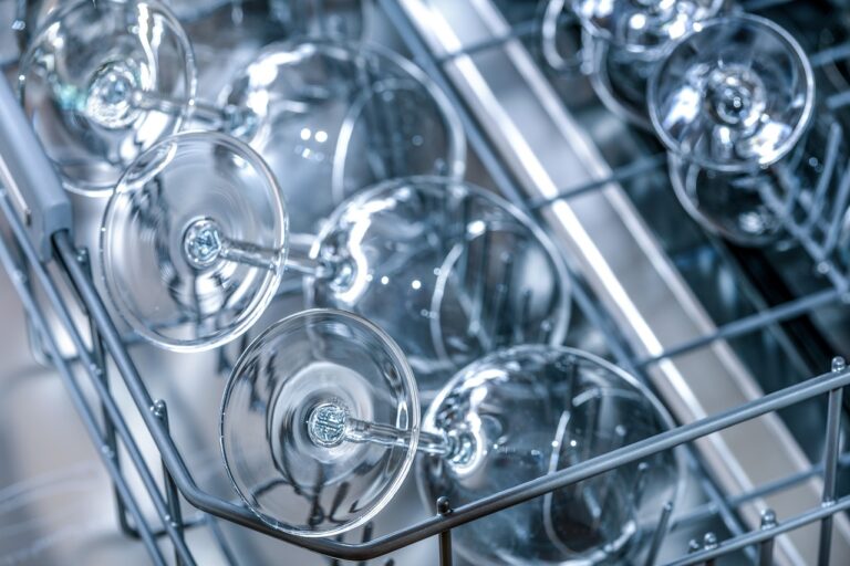 Image of wine glasses sitting in shelf. Freshly washed, shelf pulled out of dishwasher