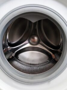 close up image of empty shining washing machine drum. Door open